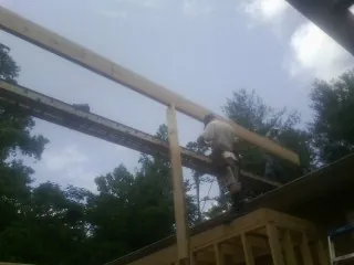 Carpenter setting a ridge beam over a new addition frame — Ice Dam Removal by Roofing Brothers in North Powder