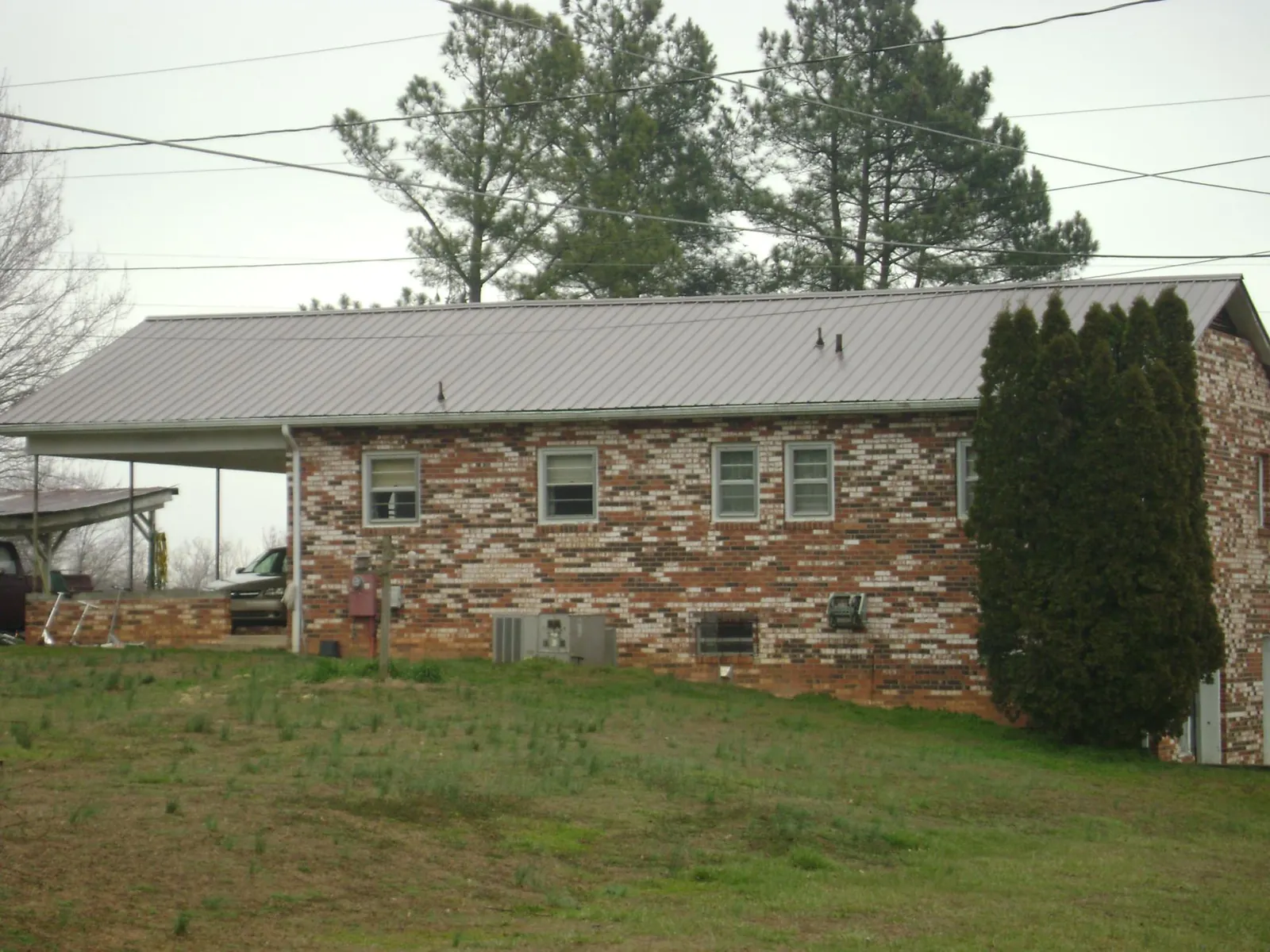 Gray metal roof on a brick split level home with a carport in North Powder