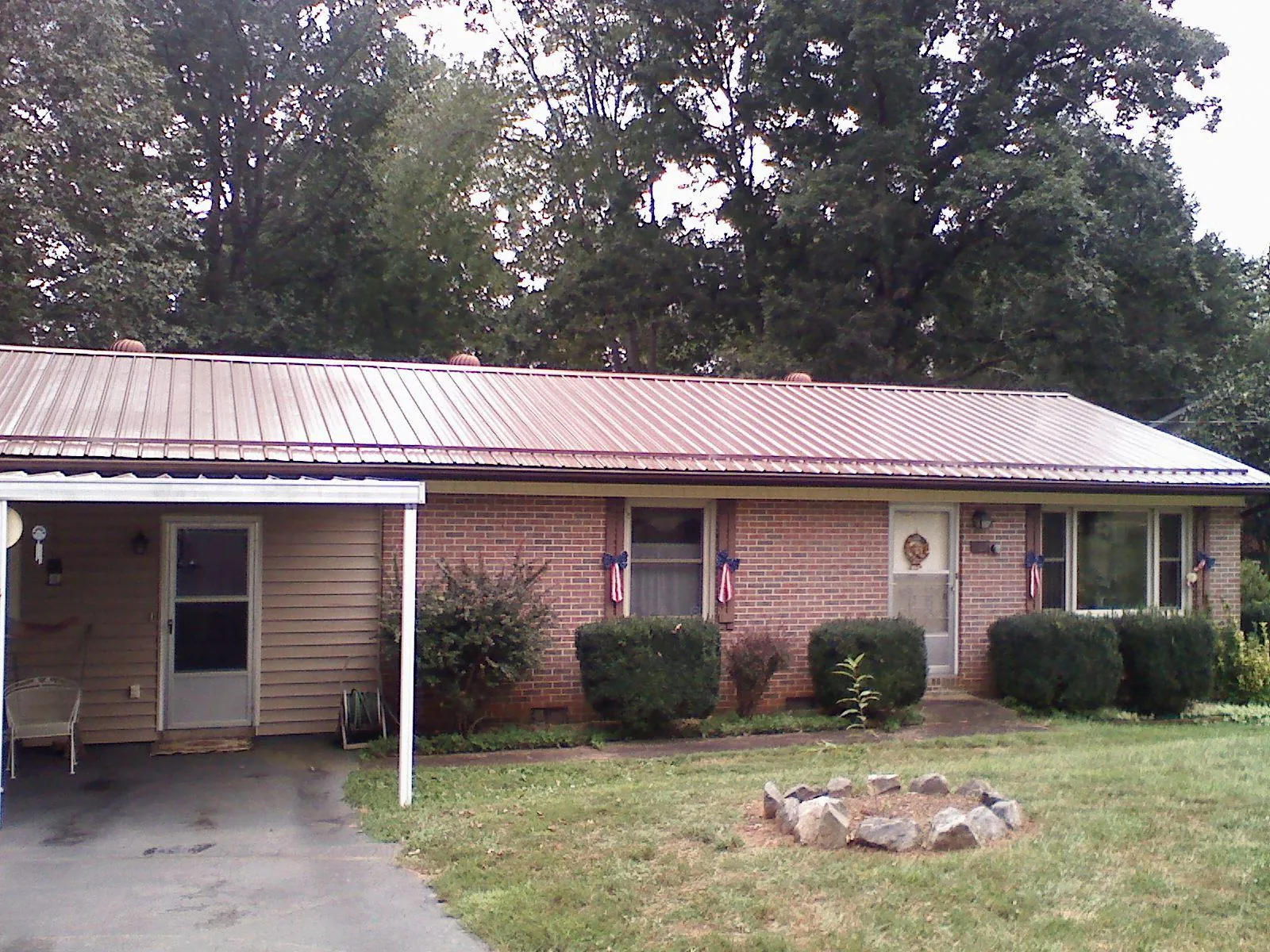 Bronze metal roof and carport on a brick ranch home — Roof Repair work by our crew in North Powder